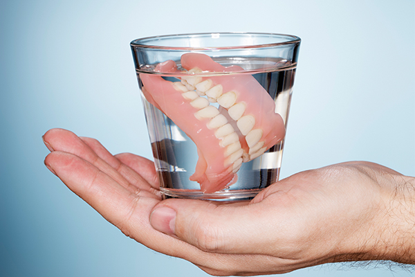 An image of a well made pair of dentures in a glass of water